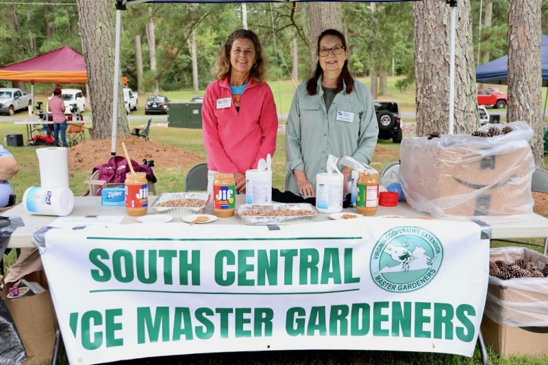 south central VCE masters gardeners, two people standing behind a table with a sign and canopy