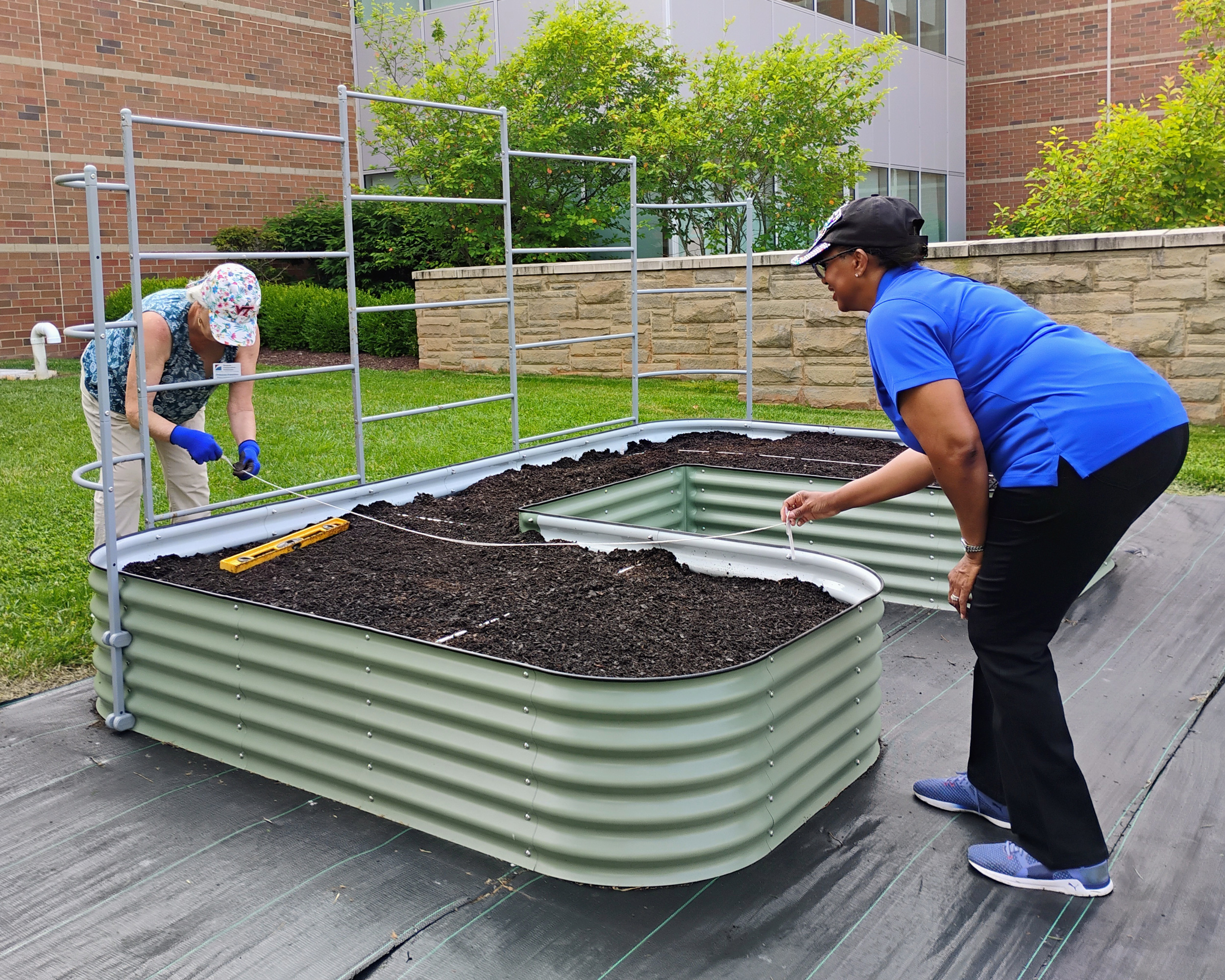 two women working in a raised garden bed